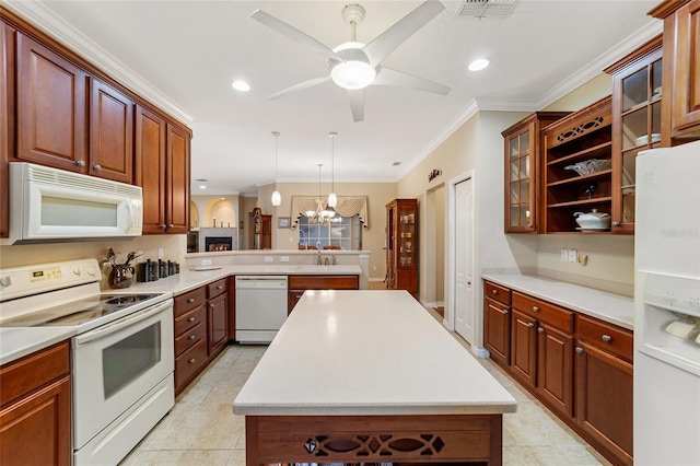 kitchen featuring white appliances, crown molding, kitchen peninsula, a kitchen island, and decorative light fixtures