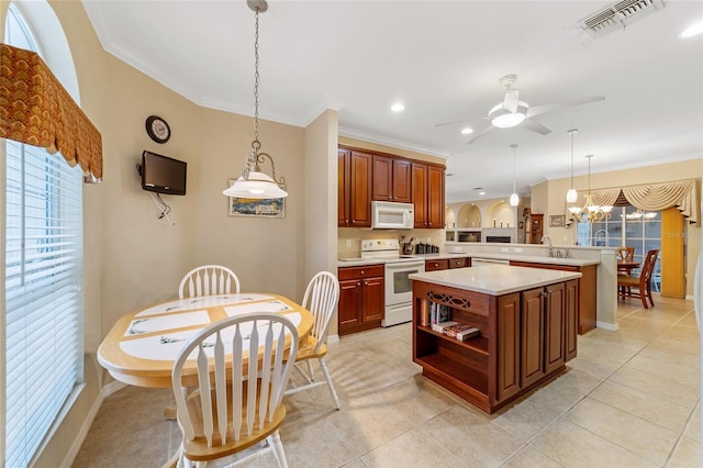 kitchen featuring white appliances, kitchen peninsula, light tile patterned floors, pendant lighting, and ceiling fan with notable chandelier