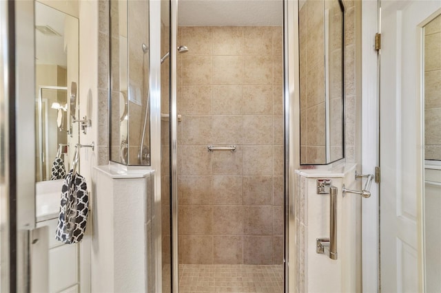 bathroom featuring a textured ceiling and a shower with door