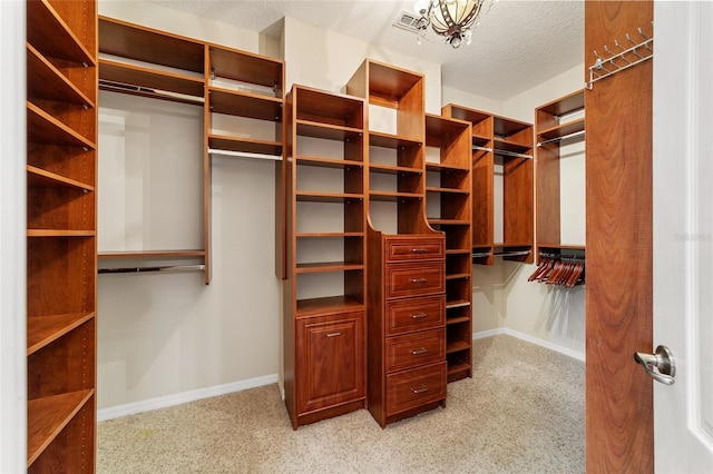 walk in closet with light carpet