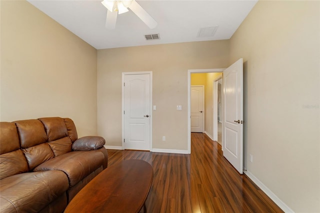 living room featuring ceiling fan and dark wood-type flooring