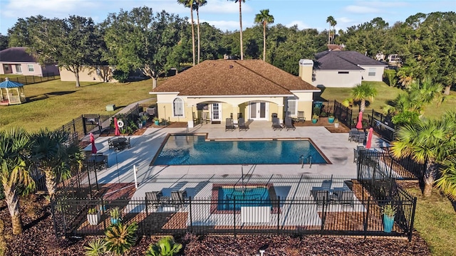 view of pool featuring a lawn, an outbuilding, and a patio