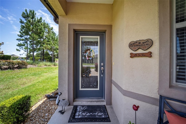 property entrance with a lawn