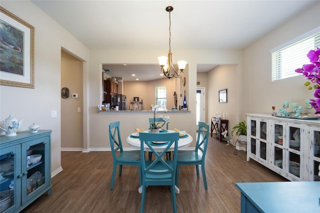 dining space with a notable chandelier, plenty of natural light, and dark wood-type flooring