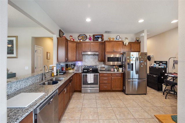 kitchen featuring light stone countertops, sink, stainless steel appliances, tasteful backsplash, and light tile patterned floors