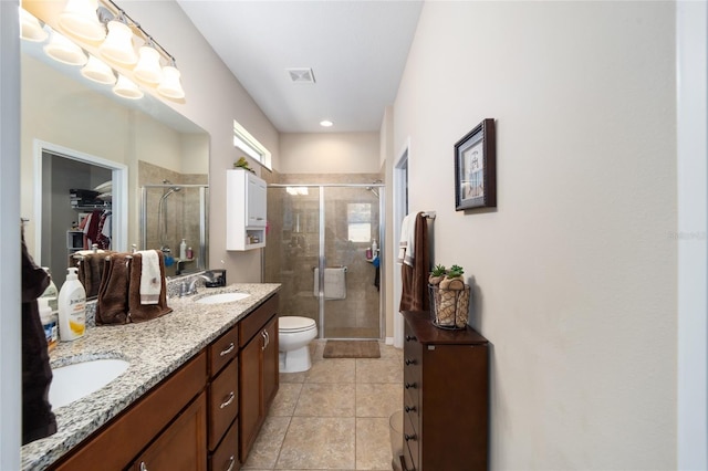 bathroom featuring tile patterned floors, vanity, toilet, and a shower with door