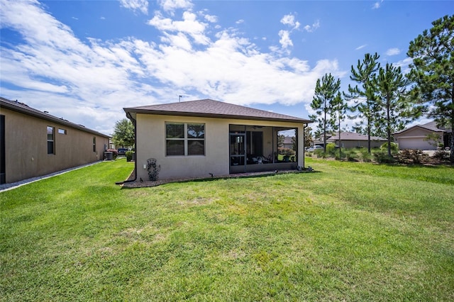 back of property featuring a sunroom and a yard