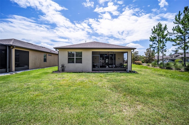 rear view of property with a yard and a sunroom