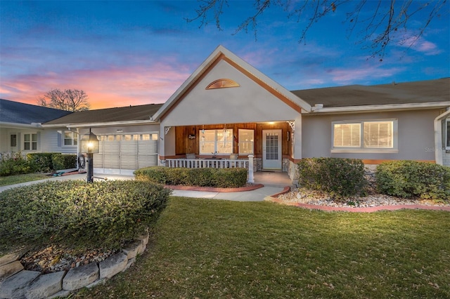 ranch-style home with a lawn, a porch, and a garage