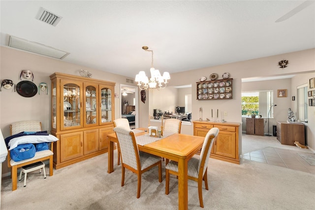 dining area featuring light carpet and an inviting chandelier