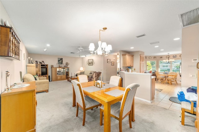 dining room featuring ceiling fan with notable chandelier and light tile patterned flooring