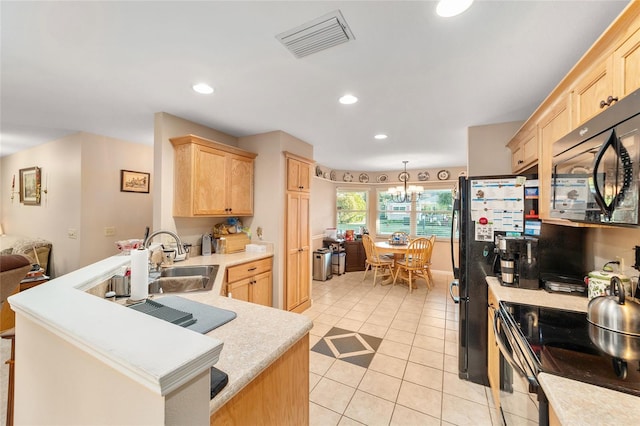 kitchen featuring black appliances, light tile patterned floors, light brown cabinetry, decorative light fixtures, and a chandelier