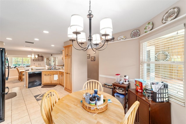 dining space featuring light tile patterned floors, sink, and a chandelier