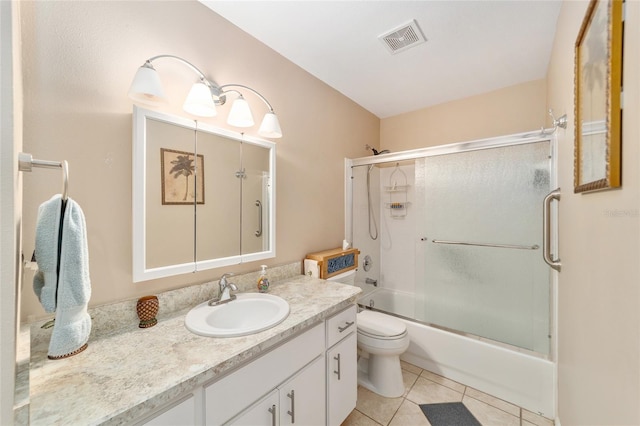 full bathroom with tile patterned floors, vanity, enclosed tub / shower combo, and toilet