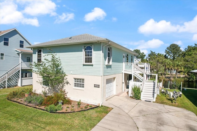 view of home's exterior featuring concrete driveway, stairway, a lawn, and stucco siding