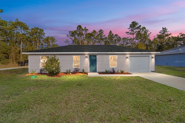 ranch-style house with a garage and a lawn