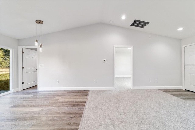 carpeted empty room featuring lofted ceiling