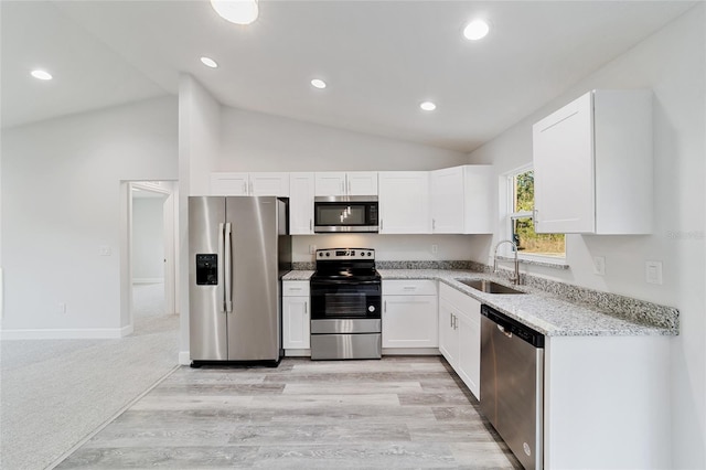 kitchen featuring white cabinets, sink, light hardwood / wood-style flooring, light stone countertops, and appliances with stainless steel finishes