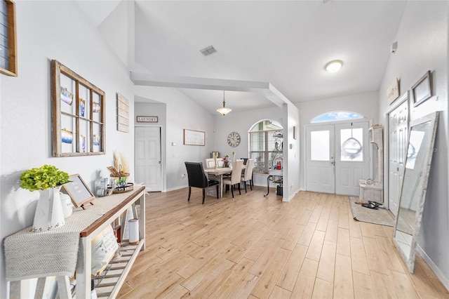 entrance foyer with lofted ceiling, light wood-type flooring, and french doors