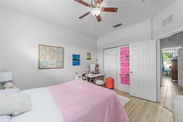 bedroom with a closet, light hardwood / wood-style flooring, and ceiling fan