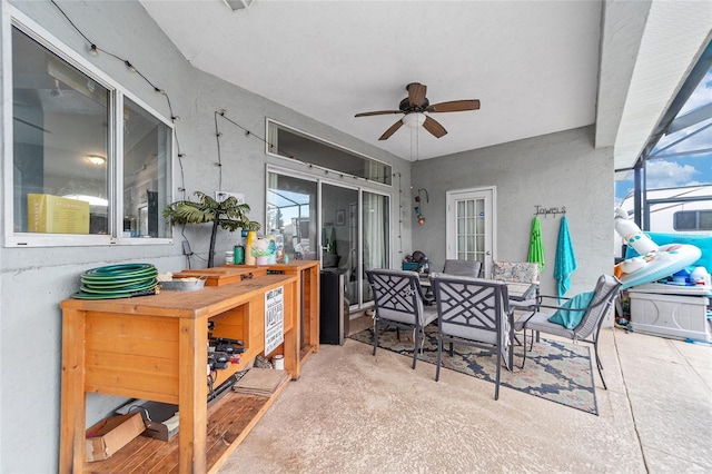 view of patio / terrace with ceiling fan, exterior bar, and glass enclosure