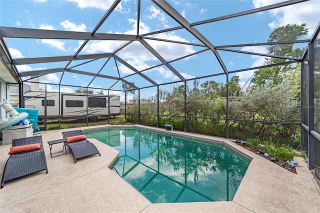 view of swimming pool with glass enclosure and a patio