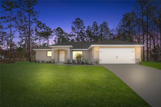 view of front of property with a yard and a garage