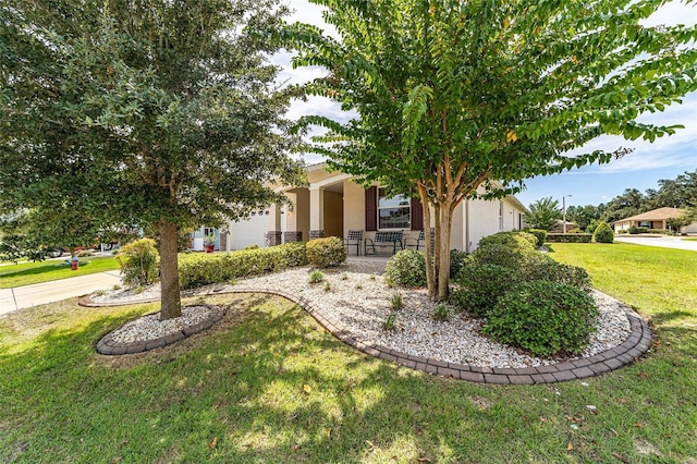 view of property hidden behind natural elements with a porch and a front lawn