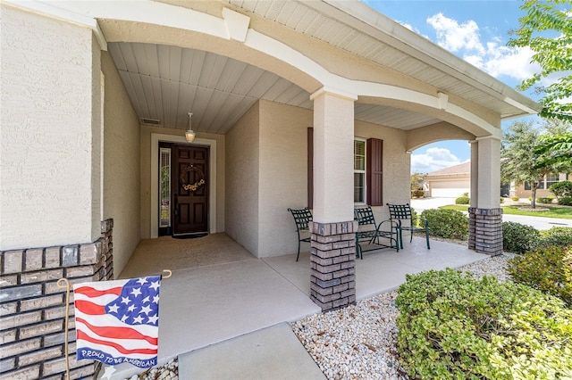 view of exterior entry with a porch