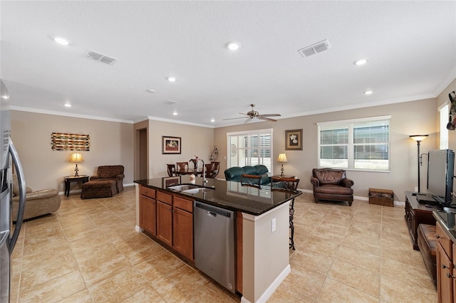 kitchen featuring sink, ceiling fan, dark stone countertops, an island with sink, and appliances with stainless steel finishes