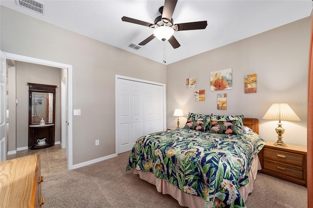 bedroom featuring ceiling fan, light carpet, and a closet