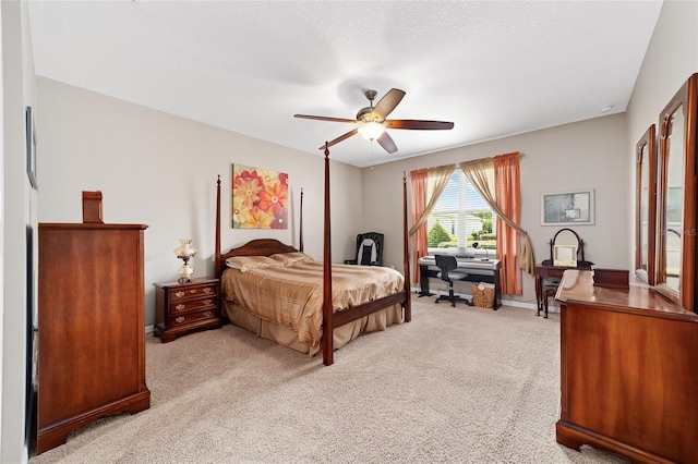 bedroom with ceiling fan, light colored carpet, and a textured ceiling