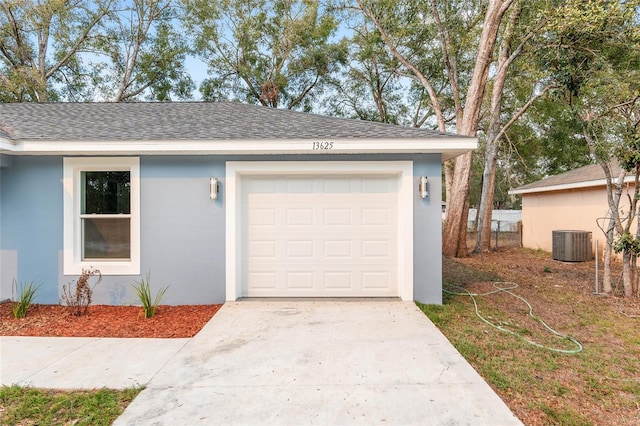 garage featuring central air condition unit and concrete driveway