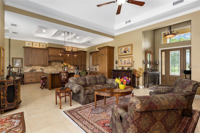 tiled living room featuring a tray ceiling, ceiling fan, and crown molding