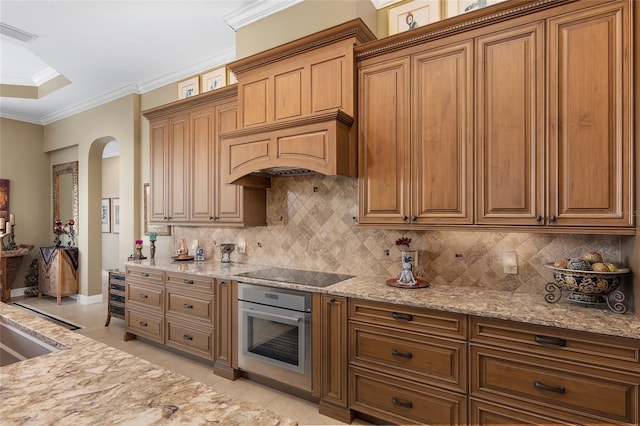 kitchen featuring light tile patterned floors, black electric cooktop, oven, and tasteful backsplash