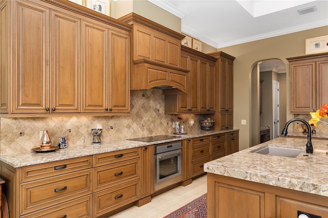 kitchen with decorative backsplash, sink, crown molding, and stainless steel oven