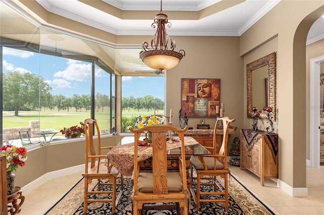 dining room featuring light tile patterned flooring, ornamental molding, and a tray ceiling