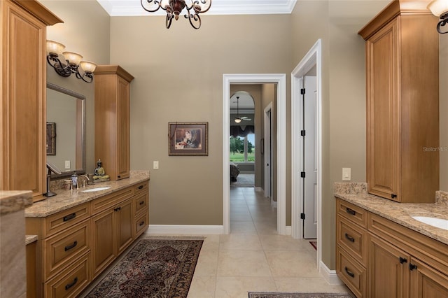 bathroom with a chandelier, vanity, tile patterned floors, and ornamental molding