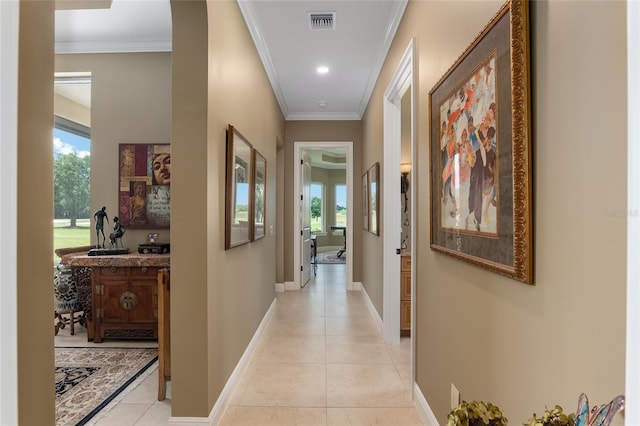 hallway with light tile patterned floors and ornamental molding