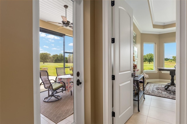 corridor featuring light tile patterned floors and ornamental molding