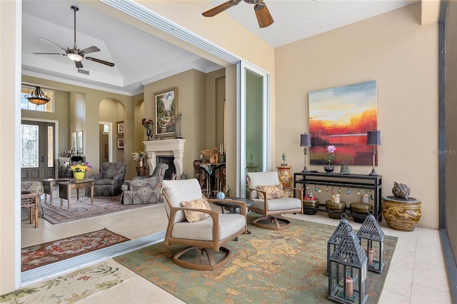 interior space featuring ceiling fan, light tile patterned flooring, ornamental molding, and a towering ceiling