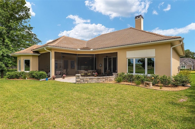 rear view of property with a yard, a patio, and a sunroom