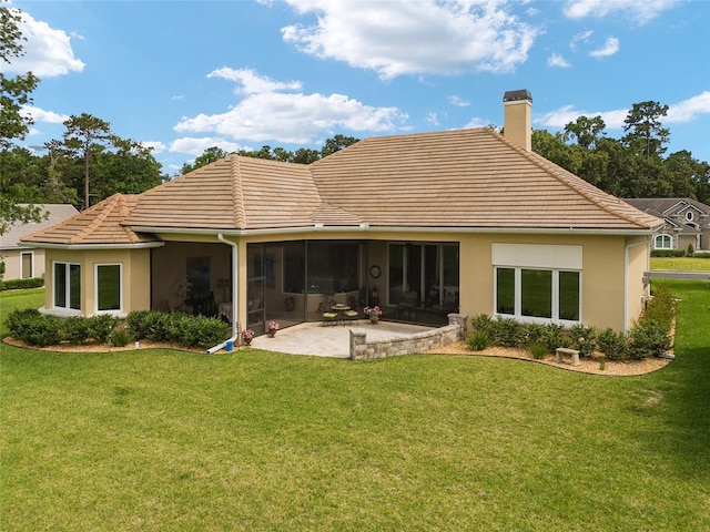 rear view of house featuring a lawn and a patio