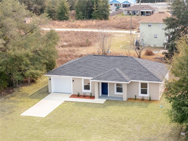 view of front of house featuring a garage, concrete driveway, roof with shingles, stucco siding, and a front yard