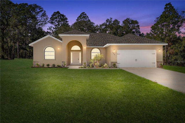 view of front of home featuring a garage and a yard