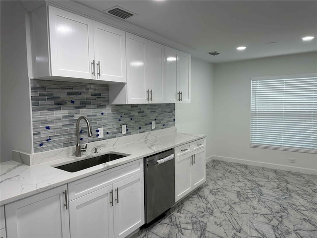 kitchen with sink, white cabinetry, light stone counters, stainless steel dishwasher, and decorative backsplash