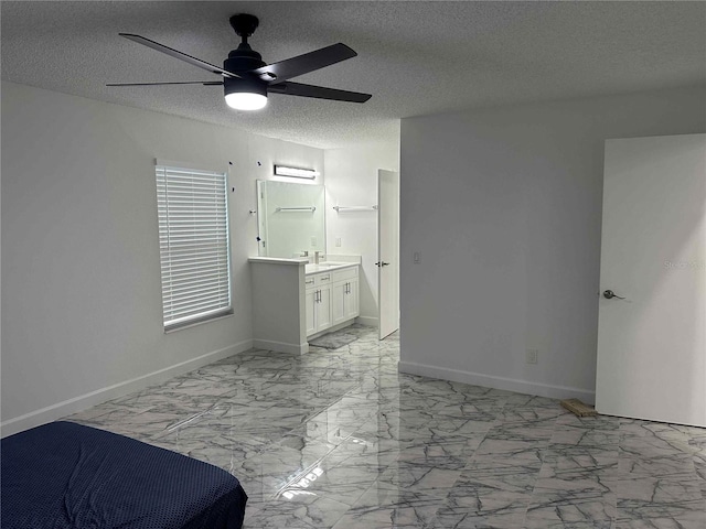 bedroom featuring ensuite bathroom, sink, a textured ceiling, and ceiling fan