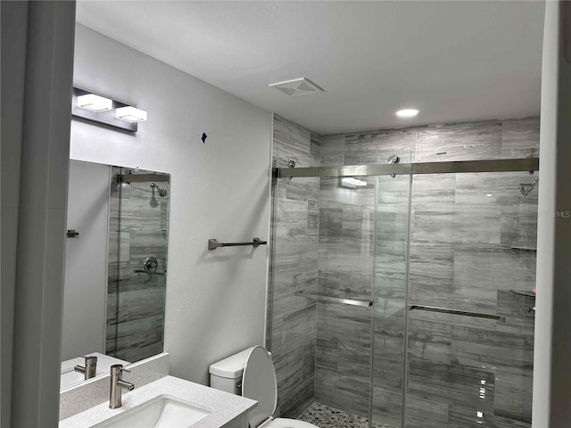 bathroom featuring vanity, an enclosed shower, and toilet