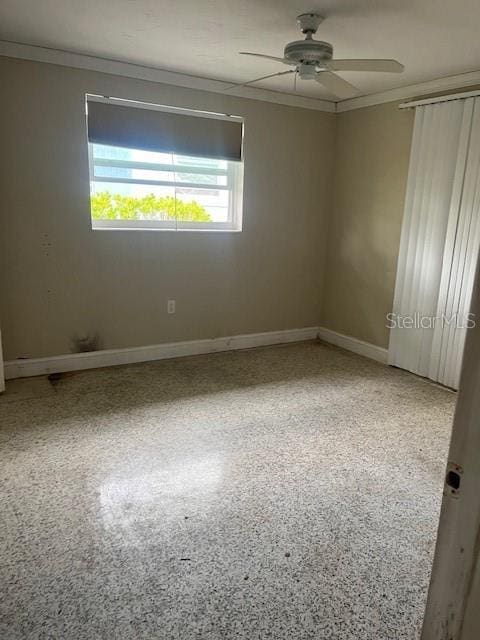 spare room with ceiling fan and crown molding