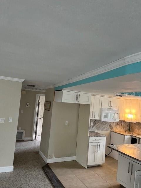 kitchen featuring white cabinets, decorative backsplash, and ornamental molding